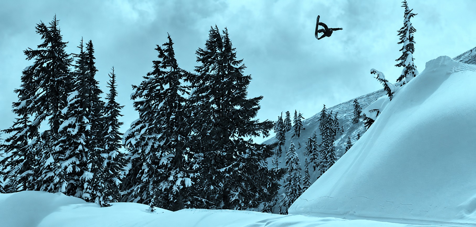 Mason Lemery en snowboard, en plein saut au-dessus d’une pente enneigée à Mt. Baker.